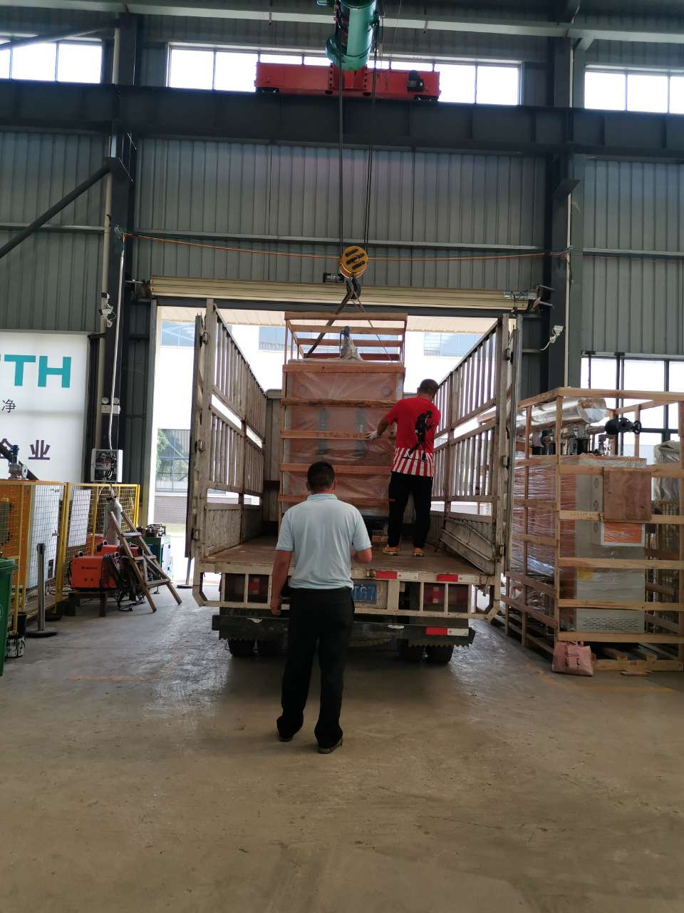 午夜一区二区三区的工作人員正在吊裝醫院用72kw電蒸汽發生器上車